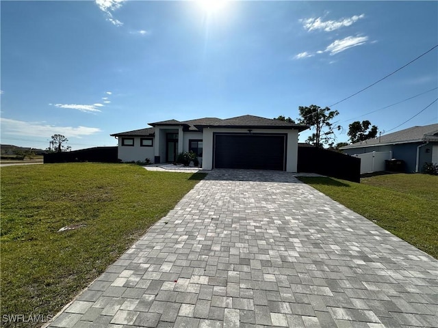 prairie-style home featuring a garage, a front yard, decorative driveway, and stucco siding