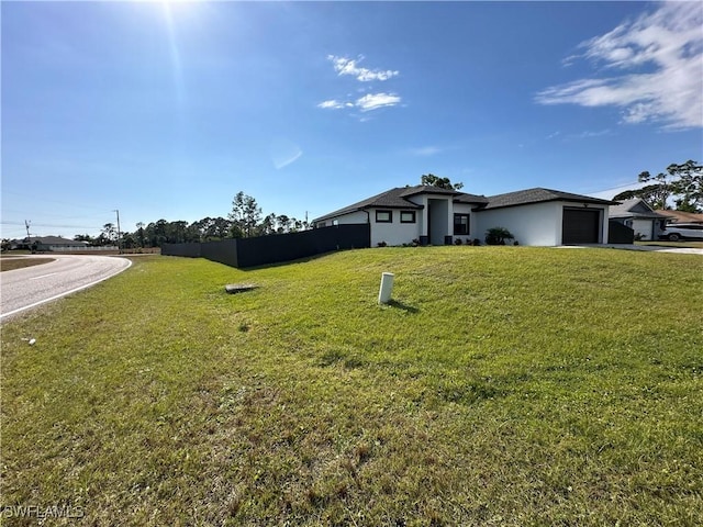 view of front facade featuring driveway, an attached garage, and a front yard