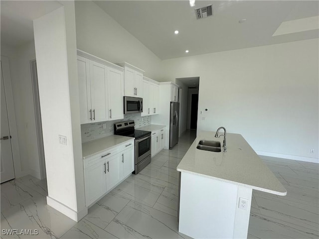 kitchen with marble finish floor, tasteful backsplash, visible vents, appliances with stainless steel finishes, and a sink