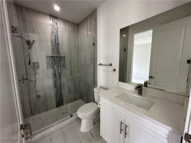 bathroom featuring a stall shower, vanity, and toilet