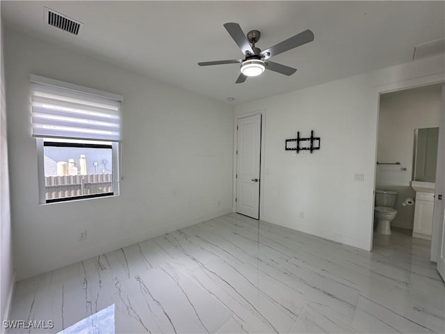 unfurnished bedroom featuring connected bathroom, a ceiling fan, visible vents, baseboards, and marble finish floor