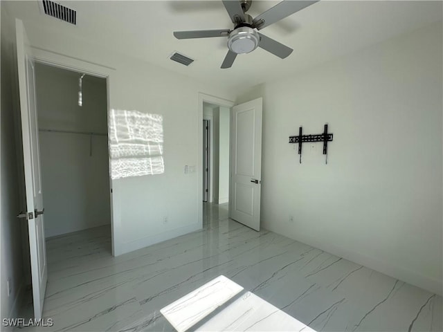 empty room with baseboards, marble finish floor, visible vents, and a ceiling fan