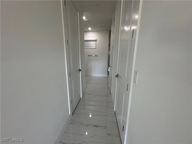 corridor featuring marble finish floor and baseboards