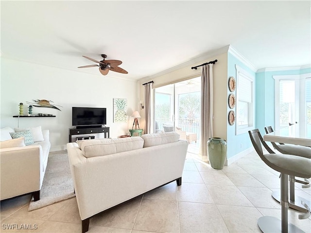 living room featuring light tile patterned floors, ceiling fan, baseboards, and crown molding