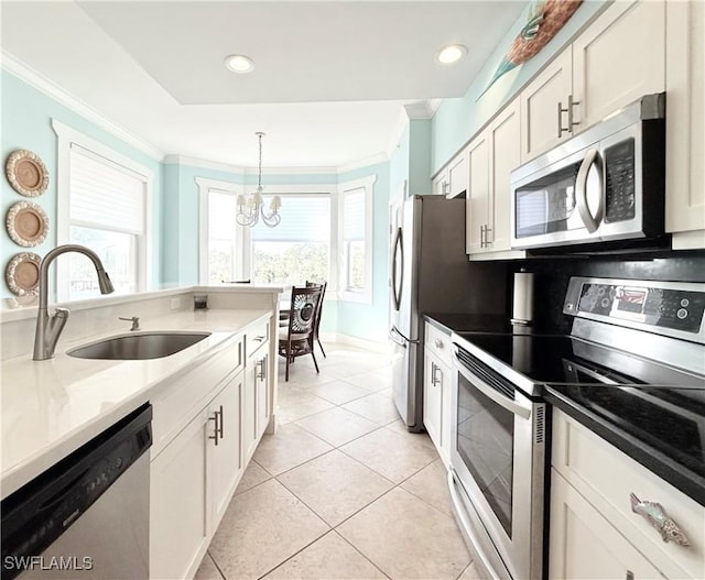 kitchen featuring a notable chandelier, decorative backsplash, appliances with stainless steel finishes, ornamental molding, and a sink