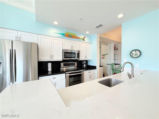 kitchen featuring a sink, white cabinetry, visible vents, appliances with stainless steel finishes, and tasteful backsplash