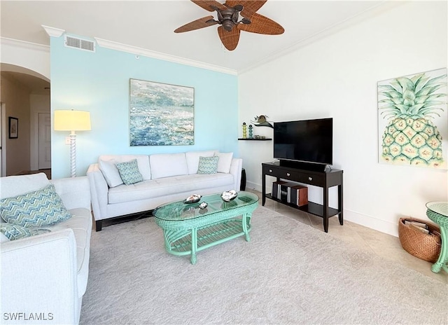 tiled living room featuring arched walkways, ceiling fan, visible vents, baseboards, and crown molding