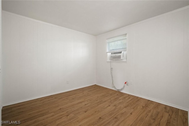 unfurnished room with cooling unit and wood finished floors