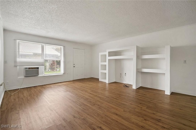 unfurnished living room with a textured ceiling, wood finished floors, and baseboards