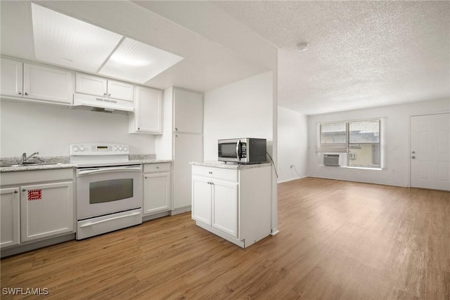 kitchen featuring light wood finished floors, white range with electric stovetop, stainless steel microwave, open floor plan, and under cabinet range hood