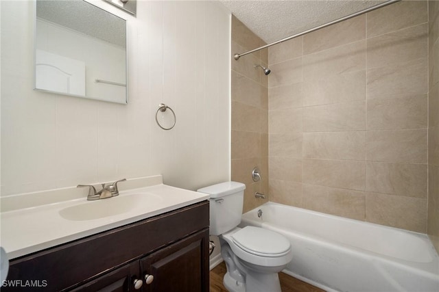 bathroom with shower / washtub combination, a textured ceiling, toilet, and vanity