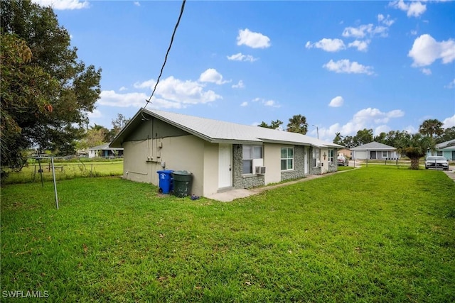 back of property featuring a lawn and stucco siding