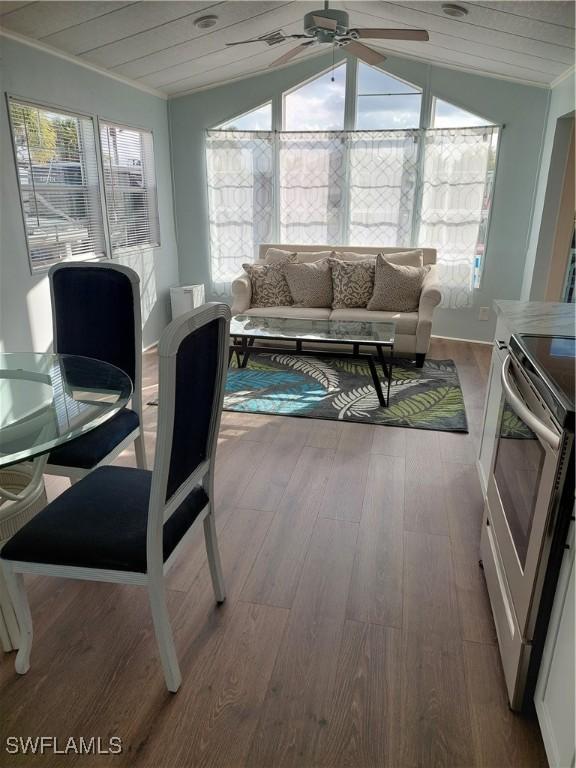 sunroom / solarium with wood ceiling, vaulted ceiling, and a ceiling fan