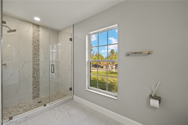 full bath featuring marble finish floor, plenty of natural light, a marble finish shower, and baseboards