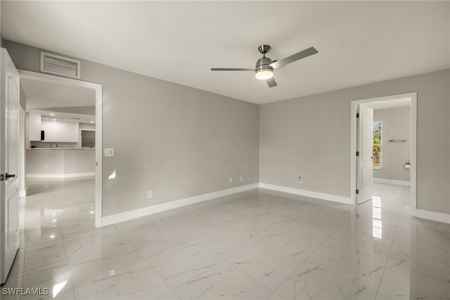 unfurnished room with marble finish floor, visible vents, and baseboards