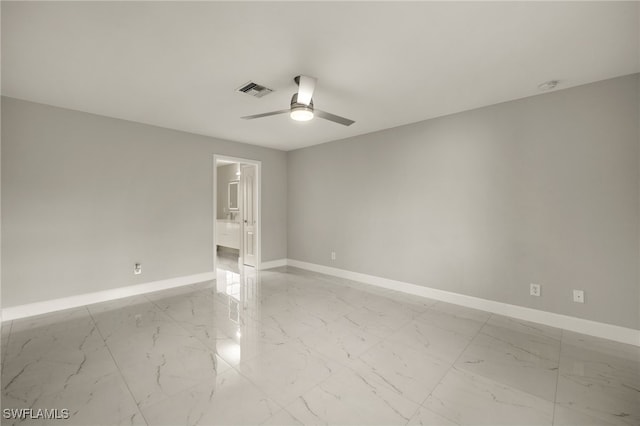 unfurnished room with marble finish floor, visible vents, baseboards, and a ceiling fan