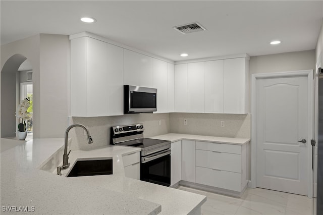 kitchen with modern cabinets, visible vents, stainless steel appliances, and a sink