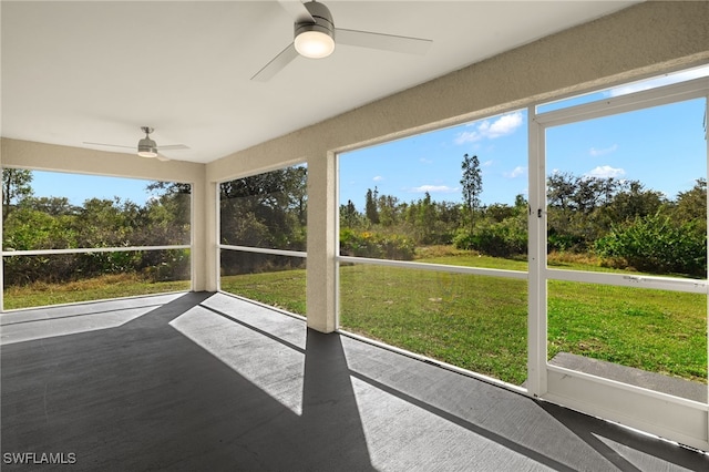 unfurnished sunroom featuring a ceiling fan