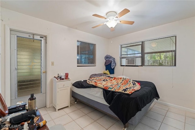 bedroom featuring ceiling fan, light tile patterned floors, cooling unit, and baseboards