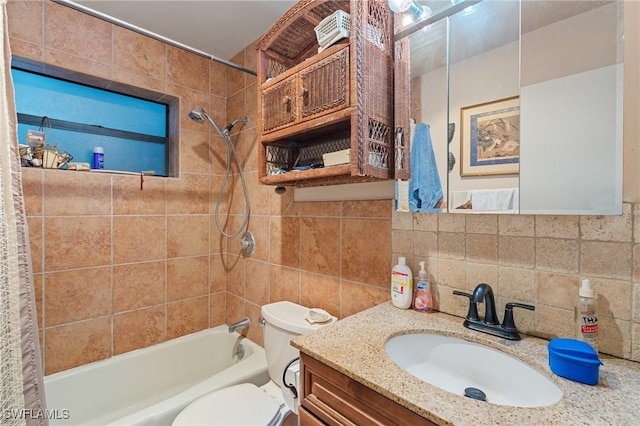 bathroom with tile walls, shower / bathing tub combination, backsplash, toilet, and vanity