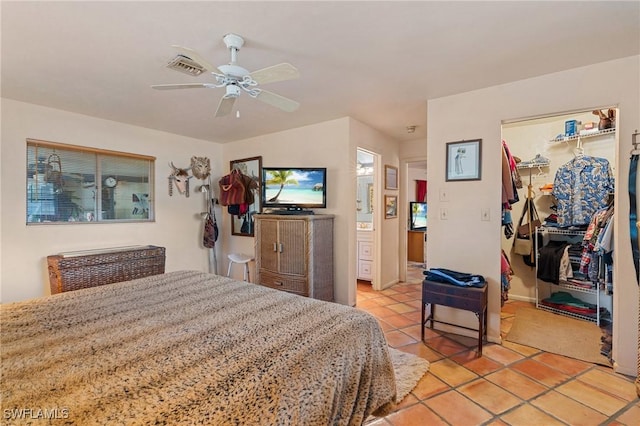 bedroom with light tile patterned floors, visible vents, a ceiling fan, a walk in closet, and a closet