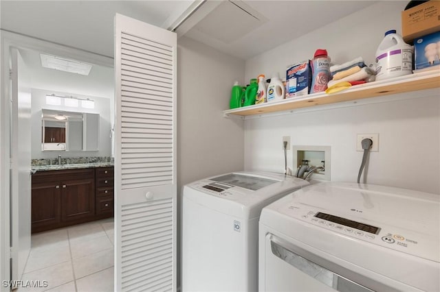 laundry room with light tile patterned floors, laundry area, separate washer and dryer, and a sink