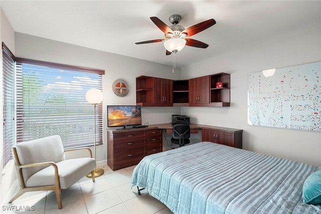 bedroom with light tile patterned floors, baseboards, a ceiling fan, and built in desk