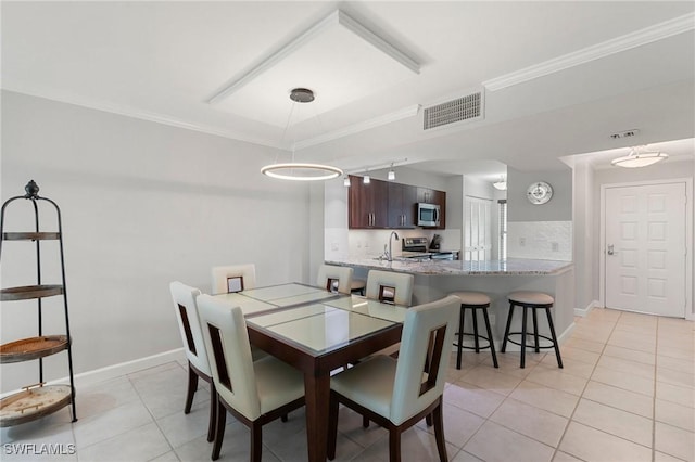 dining room featuring light tile patterned floors, baseboards, visible vents, and crown molding