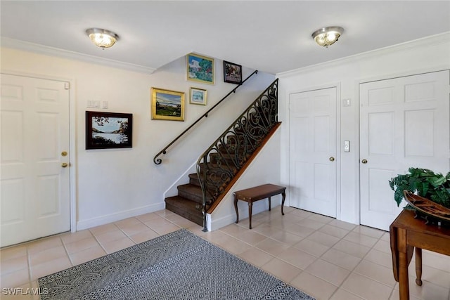 foyer with light tile patterned floors, ornamental molding, stairway, and baseboards