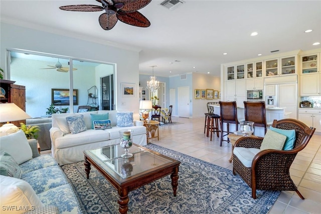 living room with light tile patterned floors, recessed lighting, ceiling fan with notable chandelier, visible vents, and crown molding