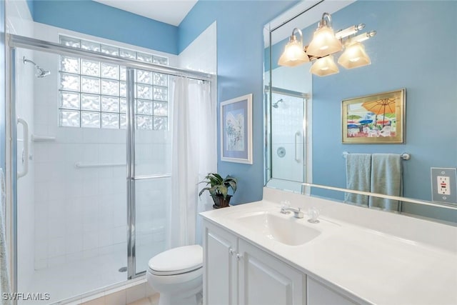 bathroom featuring a stall shower, vanity, and toilet