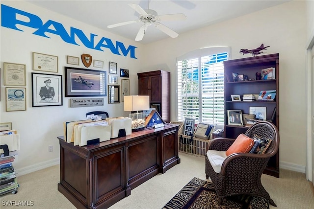 home office with light carpet, ceiling fan, and baseboards