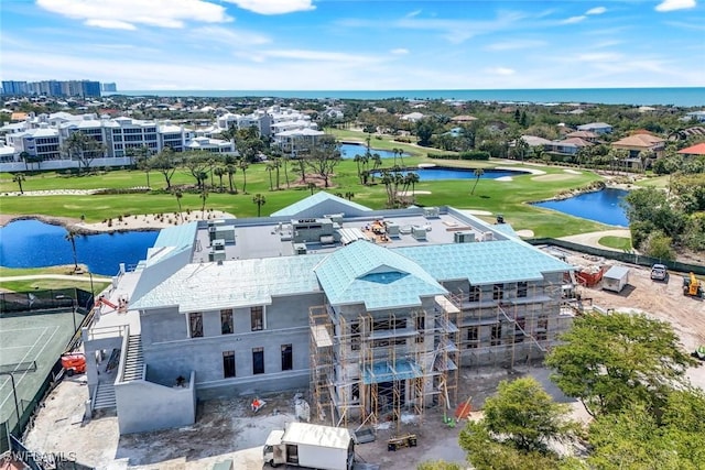 birds eye view of property with view of golf course and a water view