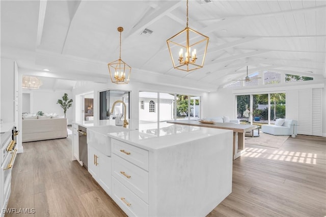 kitchen featuring open floor plan, a sink, light wood-style flooring, and white cabinetry