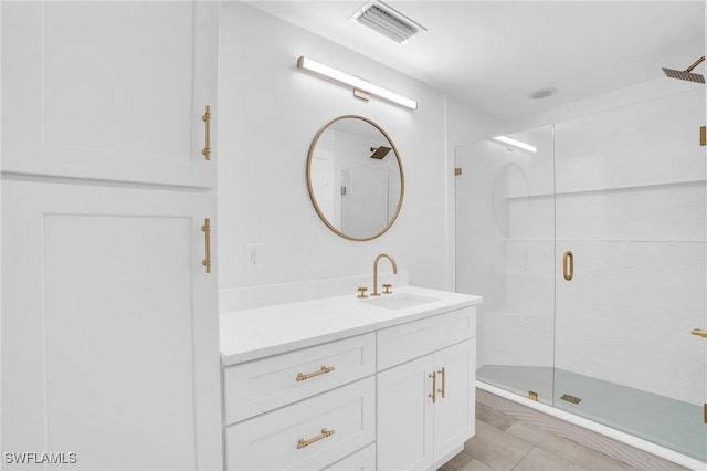 bathroom featuring visible vents, a shower stall, and vanity