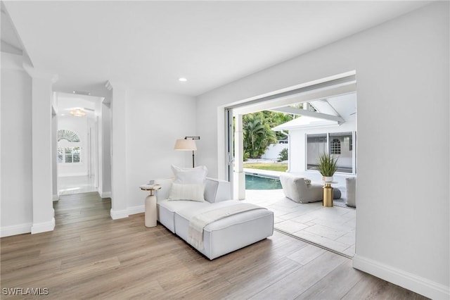 living area featuring baseboards, wood finished floors, and recessed lighting