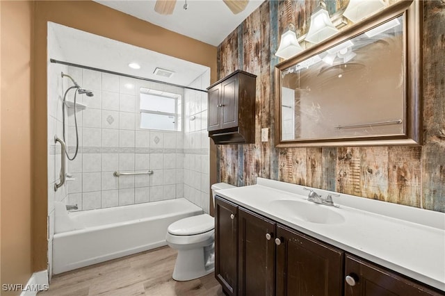 full bath featuring ceiling fan, bathtub / shower combination, toilet, wood finished floors, and vanity