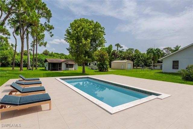 outdoor pool with a lawn, a patio, and an outdoor structure