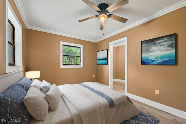 bedroom with ornamental molding, wood finished floors, a ceiling fan, and baseboards