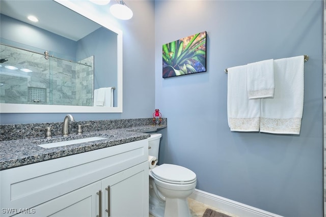 bathroom featuring toilet, a stall shower, vanity, and baseboards