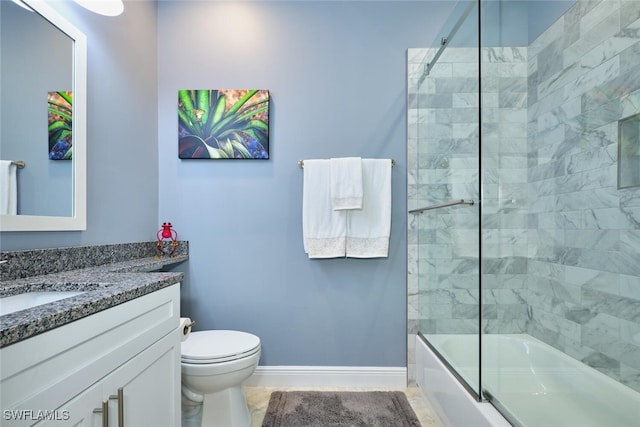 bathroom featuring bath / shower combo with glass door, vanity, toilet, and baseboards