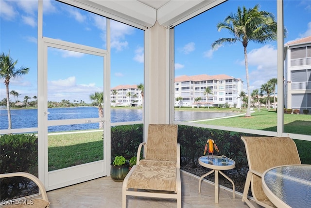 sunroom featuring a water view