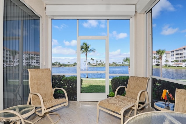 sunroom featuring a water view