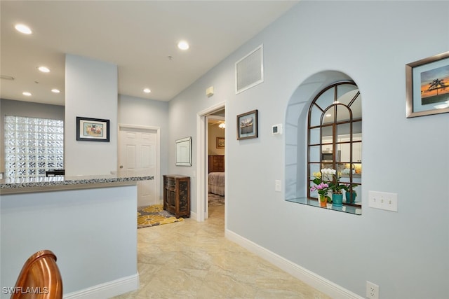 hall with baseboards, visible vents, and recessed lighting