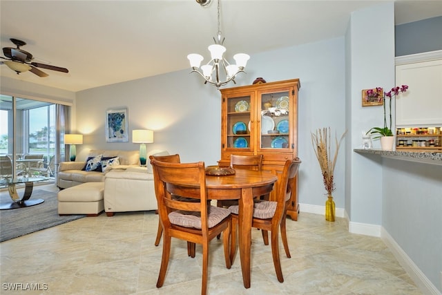 dining area featuring baseboards and ceiling fan with notable chandelier