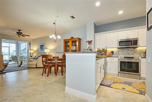 kitchen with a peninsula, visible vents, white cabinets, appliances with stainless steel finishes, and backsplash