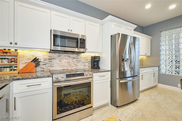 kitchen with dark stone counters, appliances with stainless steel finishes, and white cabinetry