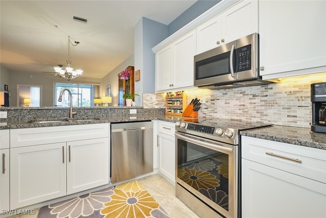 kitchen featuring stainless steel appliances, a sink, visible vents, white cabinets, and tasteful backsplash