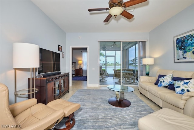 living room featuring ceiling fan, baseboards, and light tile patterned floors