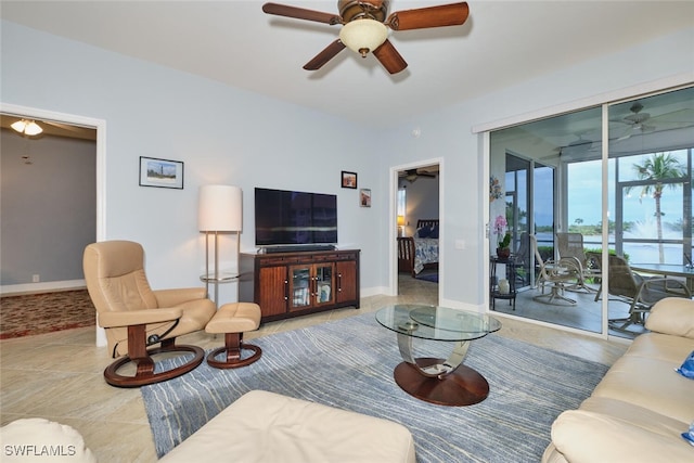 living room featuring baseboards, a ceiling fan, and tile patterned floors